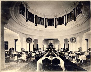 large empty dining room, many tables and chairs set for dinner
