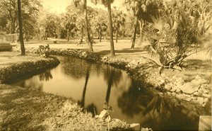 historic photo of creek winding through a park. trees and grasses on both sides of creek