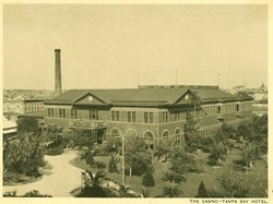 historic photo of large brick building rising out of trees