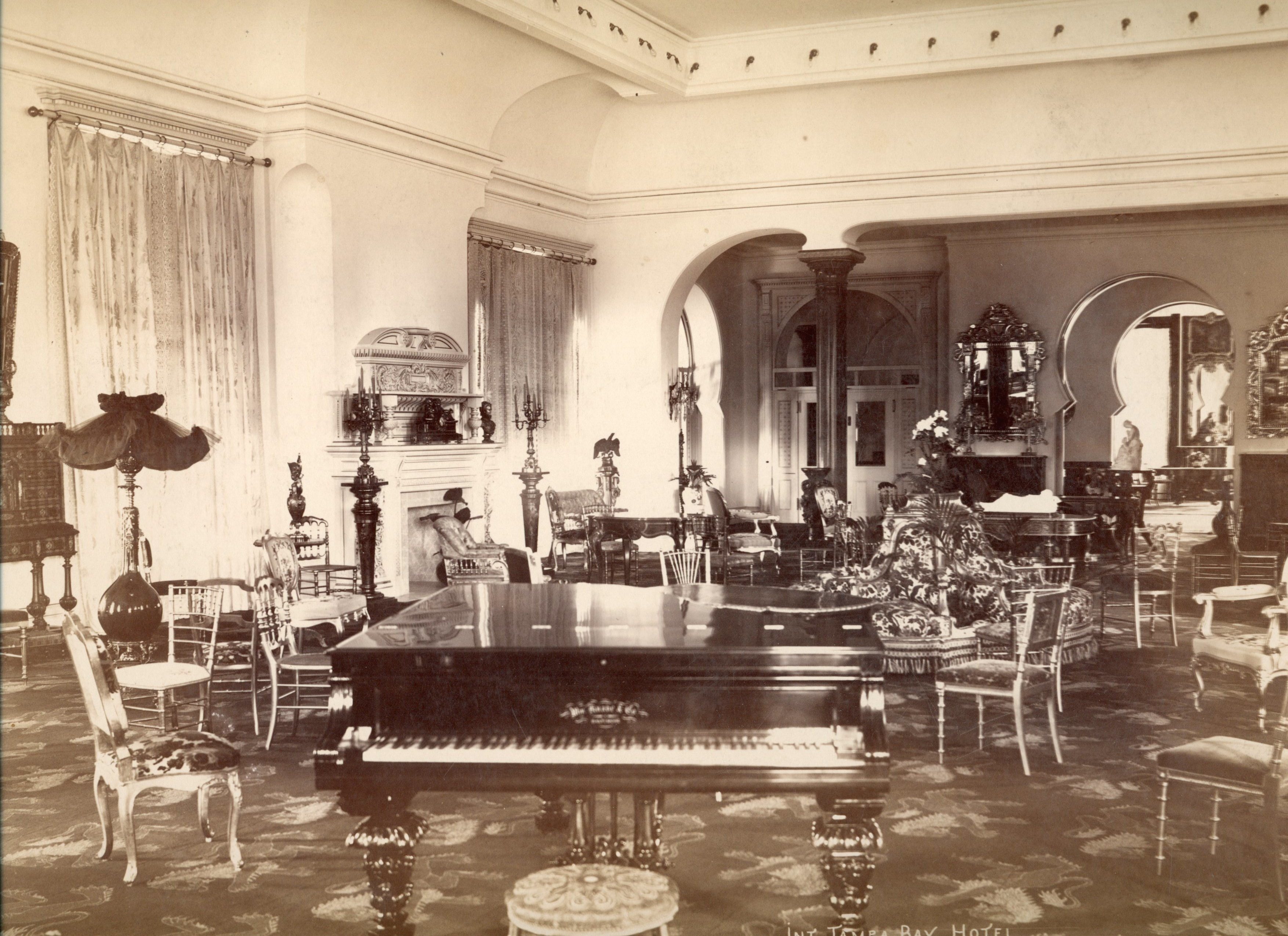 interior room, fancy chairs and sculptures scattered throughout, grand piano in foreground