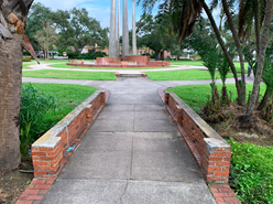concrete sidewalk making a small bridge with trees on both sides