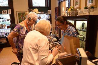 Volunteer and guests in museum store