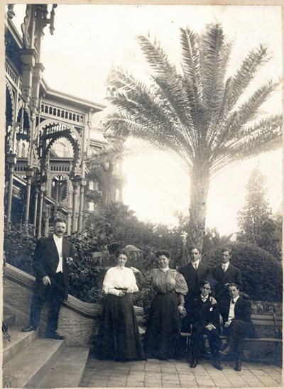 historic photo of group of people wearing formal, old-fashioned clothing outside Tampa Bay Hotel. 5 men and 2 women