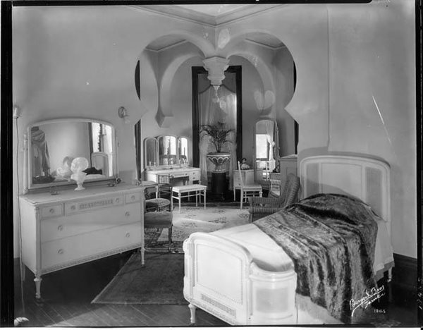 historic photo of hotel bedroom with sitting area, lavishly furnished