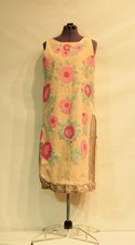 Sleeveless, silk, knee length gown with intricate floral designs and beading on mannequin