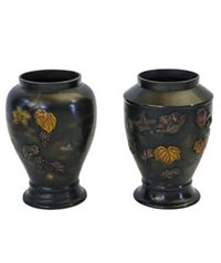 two bronze vases decorated with flowers and leaves