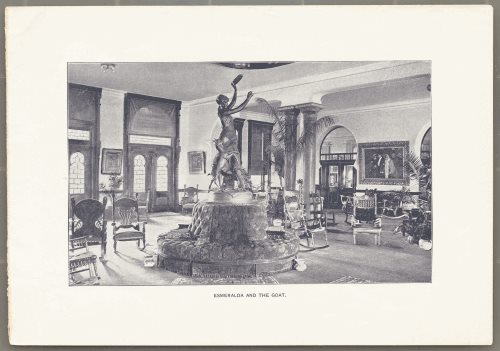 large atrium with numerous statues, potted plants and chairs. Esmerelda statue in center above round pouf.