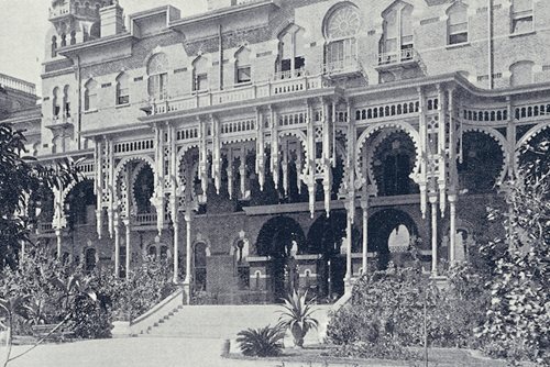 historic photo showing East Front veranda, double row of gingerbread woodwork and lush greenery