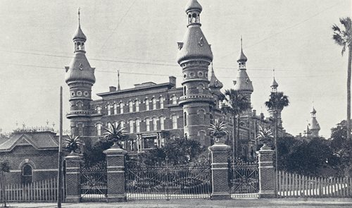 historic photo of south entrance to Hotel, ornate wrought iron gates with brick pillars fencing Hotel off from street